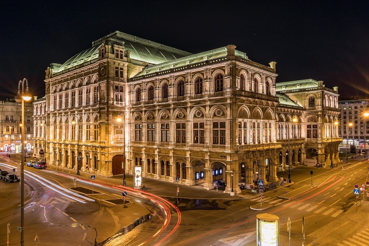 Edificio dell'Opera di Vienna di notte con le luci delle automobili