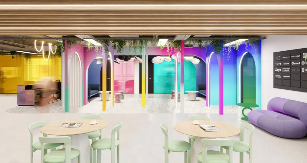 Colorida sala comune nel coworking con tavoli e divani