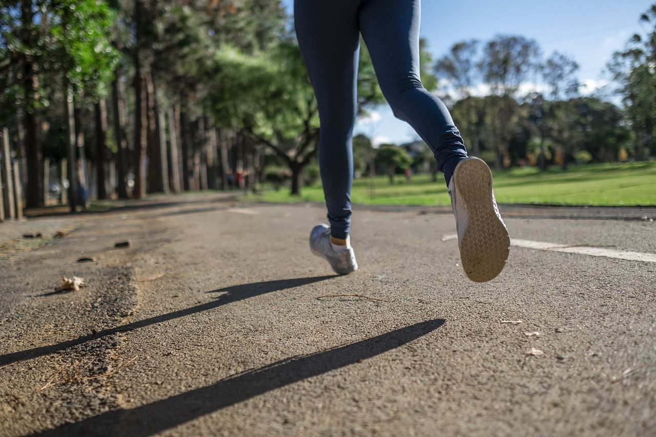 Detalle de las piernas de una persona corriendo en el parque