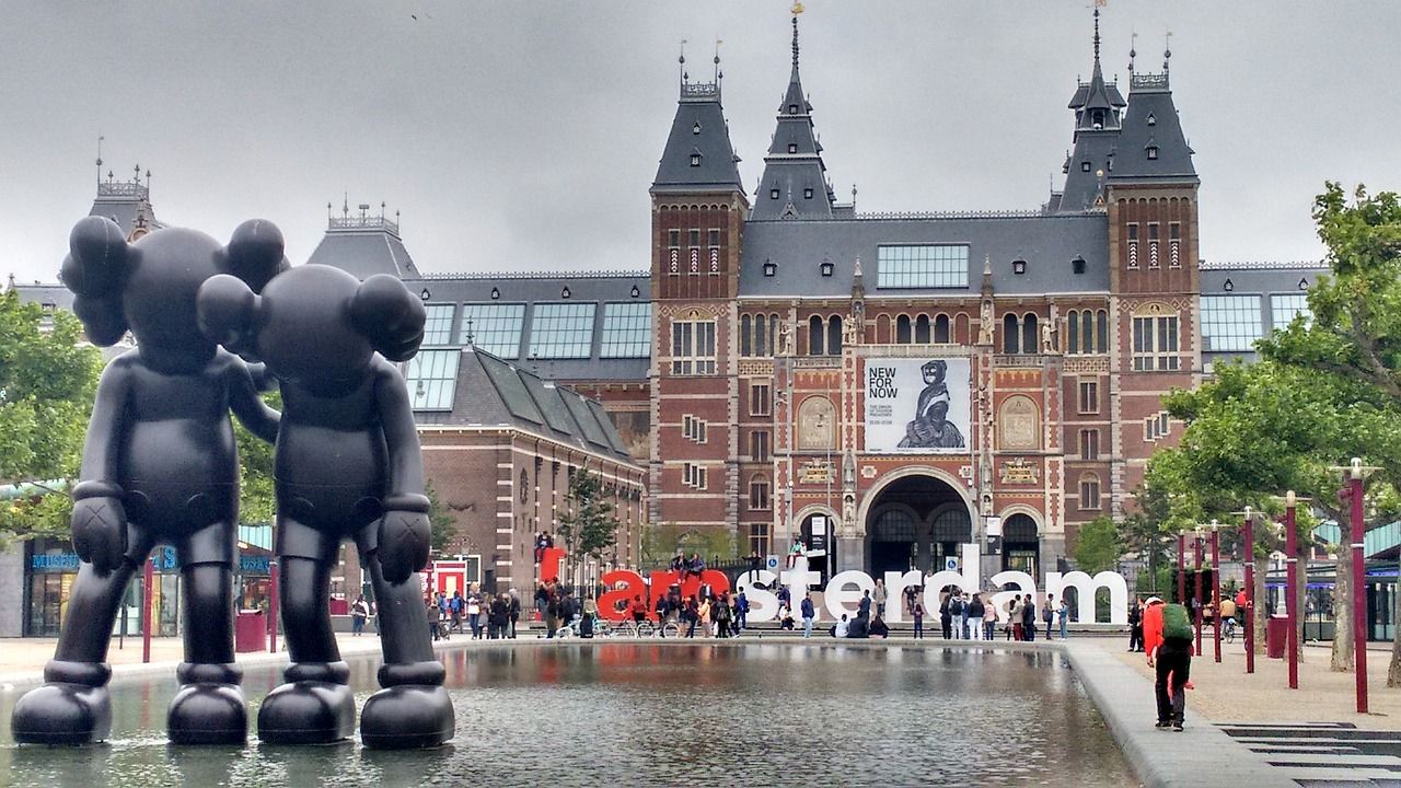 Skulpturen auf einem Amsterdamer Brunnen vor einem historischen Gebäude