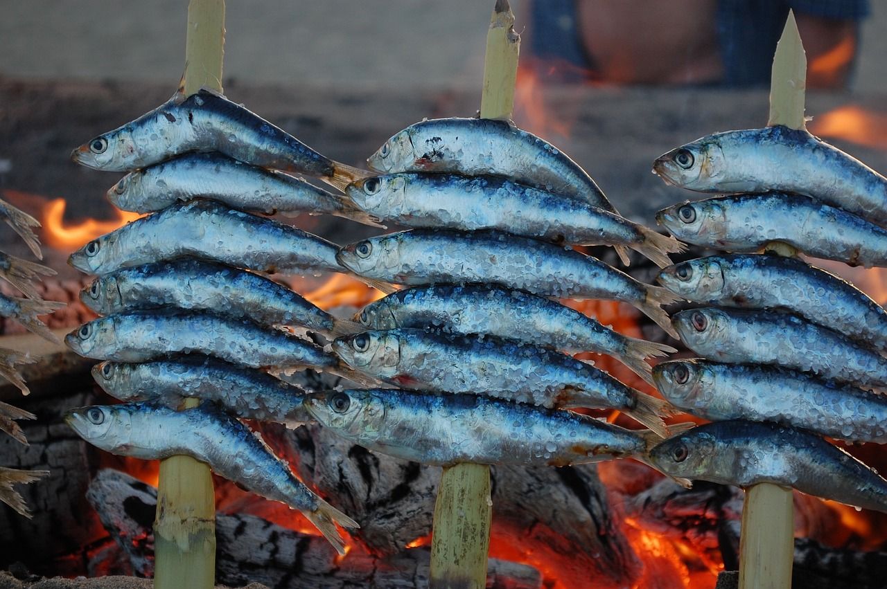Espetos, sardinas insertadas en pinchos de madera haciéndose al fuego