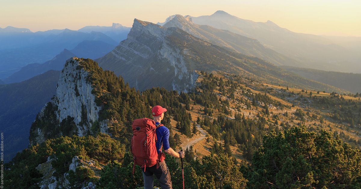 Randonneur devant le paysage montagneux du Massif