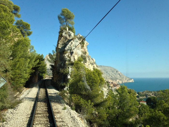 Vias de tren en medio de un paisaje natural de verde y mar