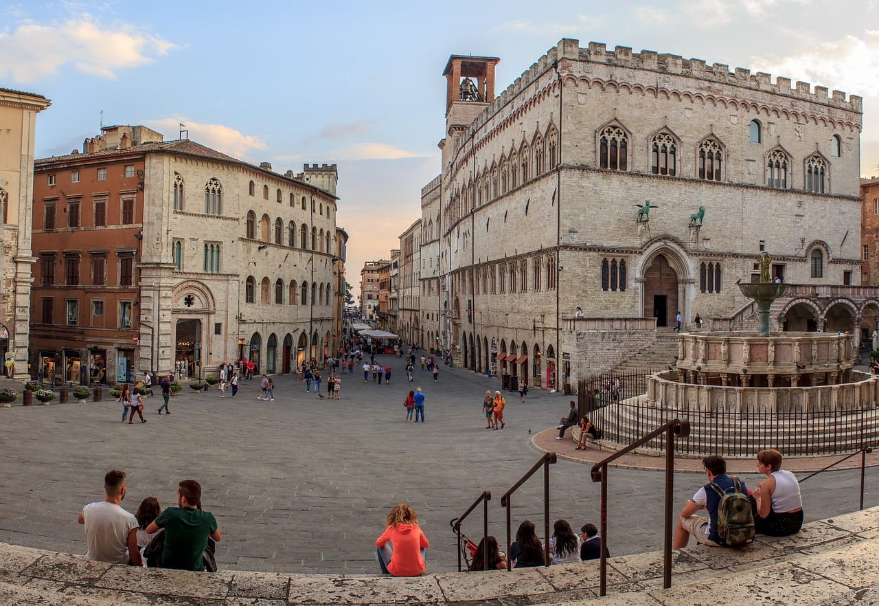 Piazza di Perugia con edifici storici e gente che cammina