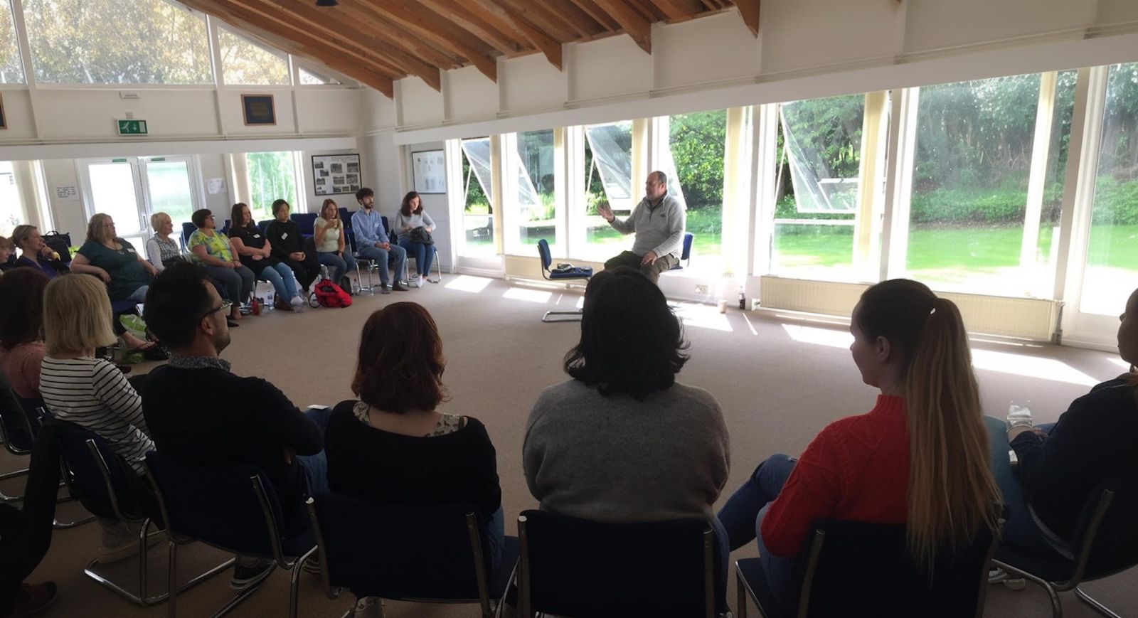 Robert teaching in a well lit hall to students on a retreat.