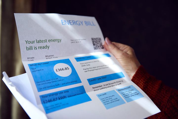 Someone holding an electric bill. They are not on screen, the focus is on the bill