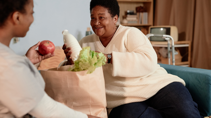 Person bringing shopping to older person.
