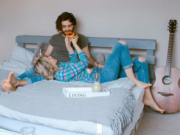 Palettenbett selber bauen – gemütliches Bett aus Europaletten mit Matratze und Decke im modernen Schlafzimmer.