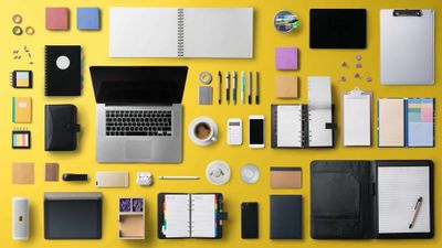 Flat lay top view office desk working space with laptop on yellow background