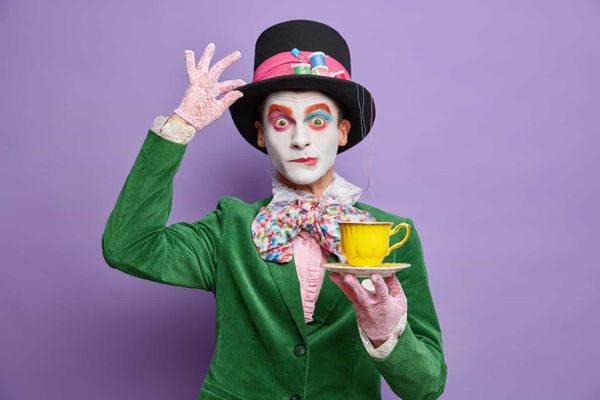 Time for having tea. Aristocratic gentleman with bright makeup has image of fictional character hold