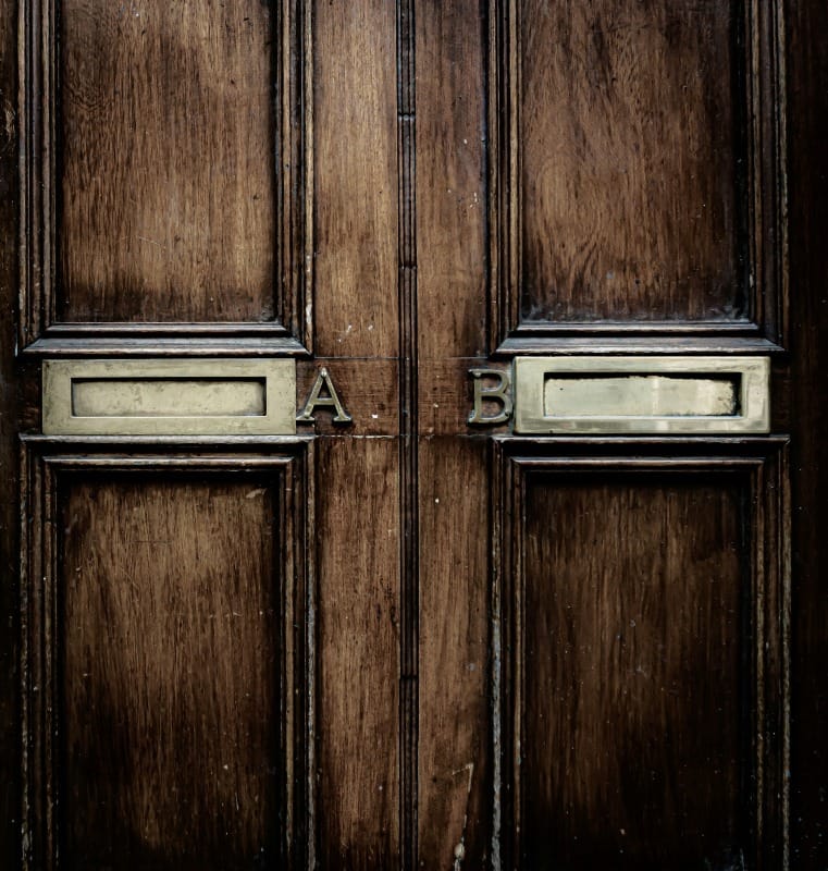 Brown wooden door with two letterboxes that are marked A and B