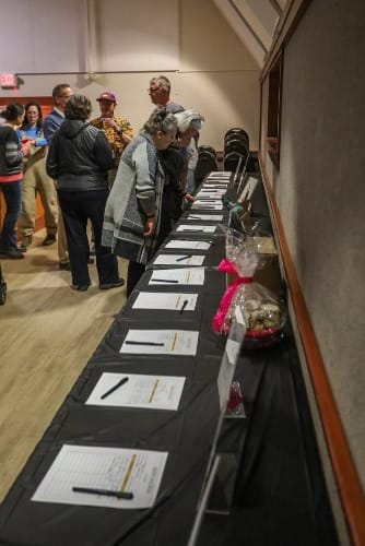 Mat-Su Untold attendees visit the silent auction table on Feb. 7, 2025.