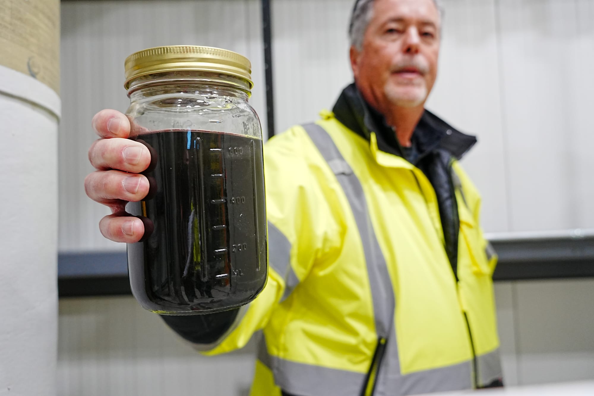 Matanuska-Susitna Borough Central Landfil Manager Jeff Smith holds a jar of untreated leachate