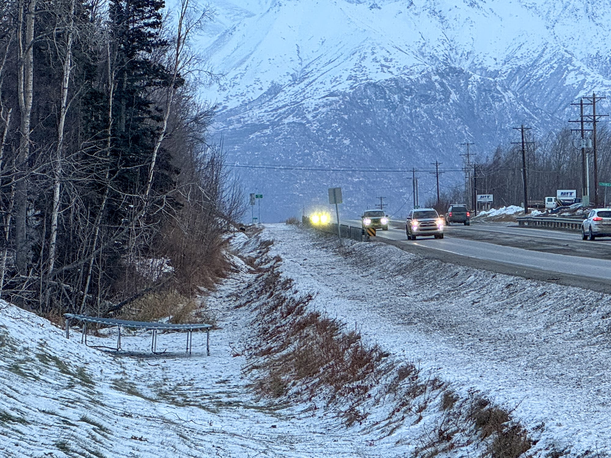 A trampoline rests in a ditch off the Palmer-Wasilla Highway