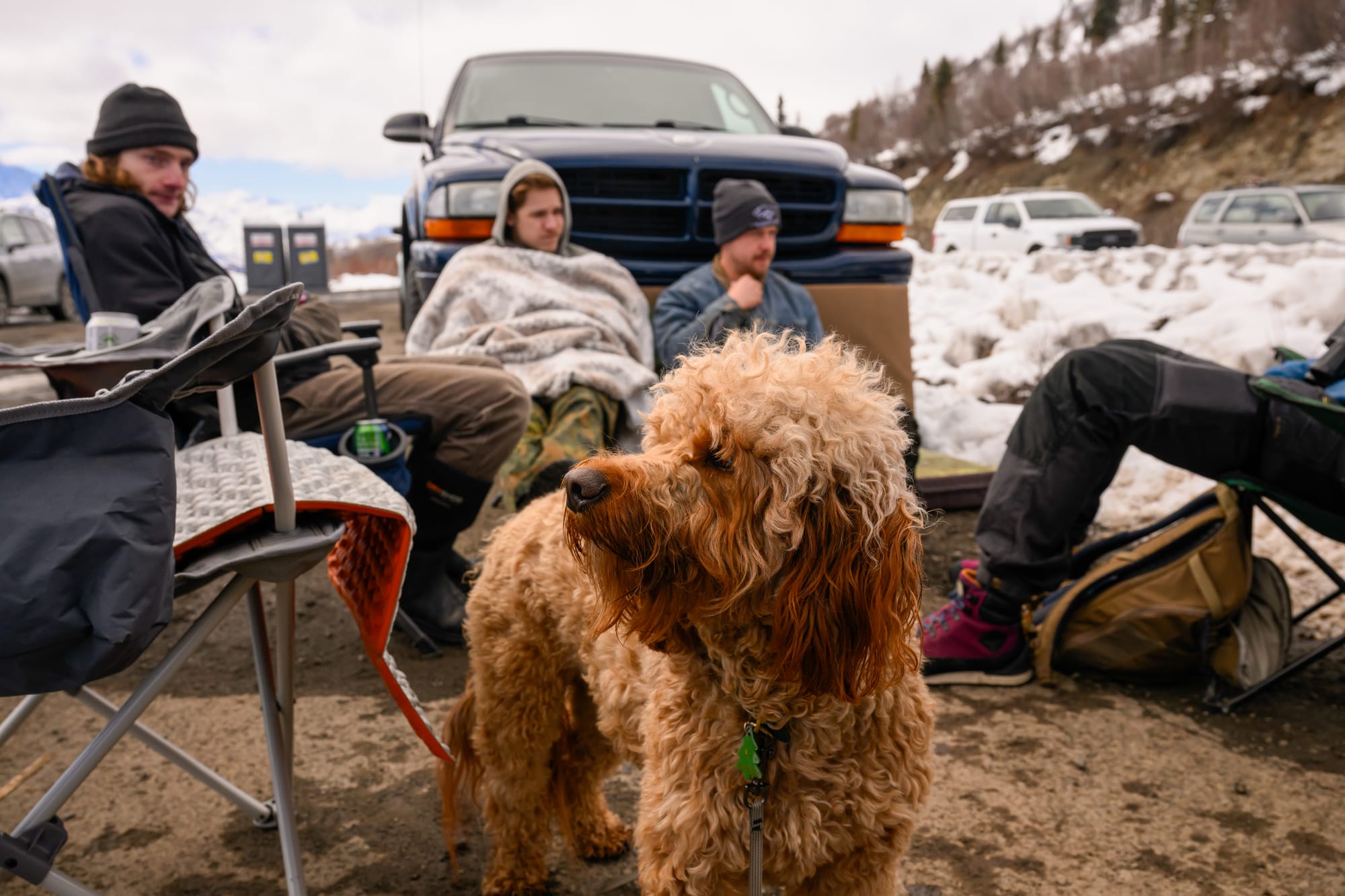 Cedar the dog stands in front of Landon Nicholson, Trapper Gebhart and Eli Seward