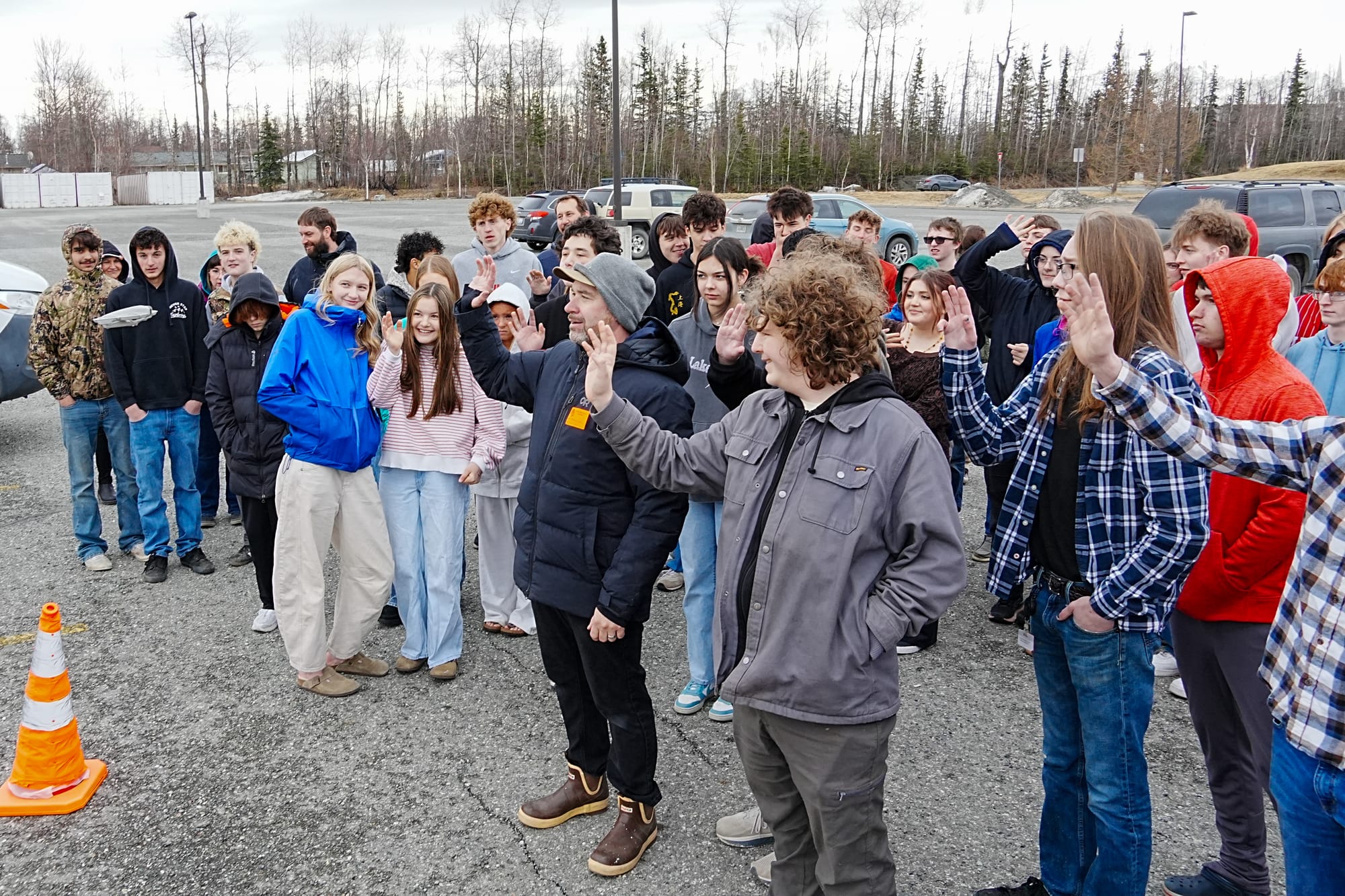 AK Drone co-founder Thomas Trapp and students wave at a hand-sized drone