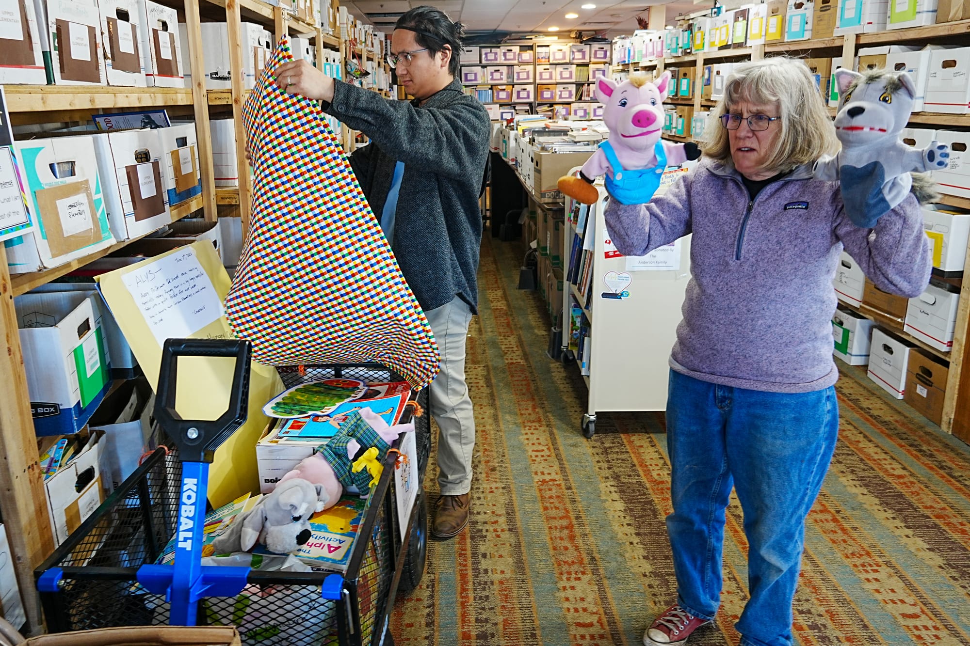 Lawrence Giron and Alys Culhane sort through donated books classroom supplies
