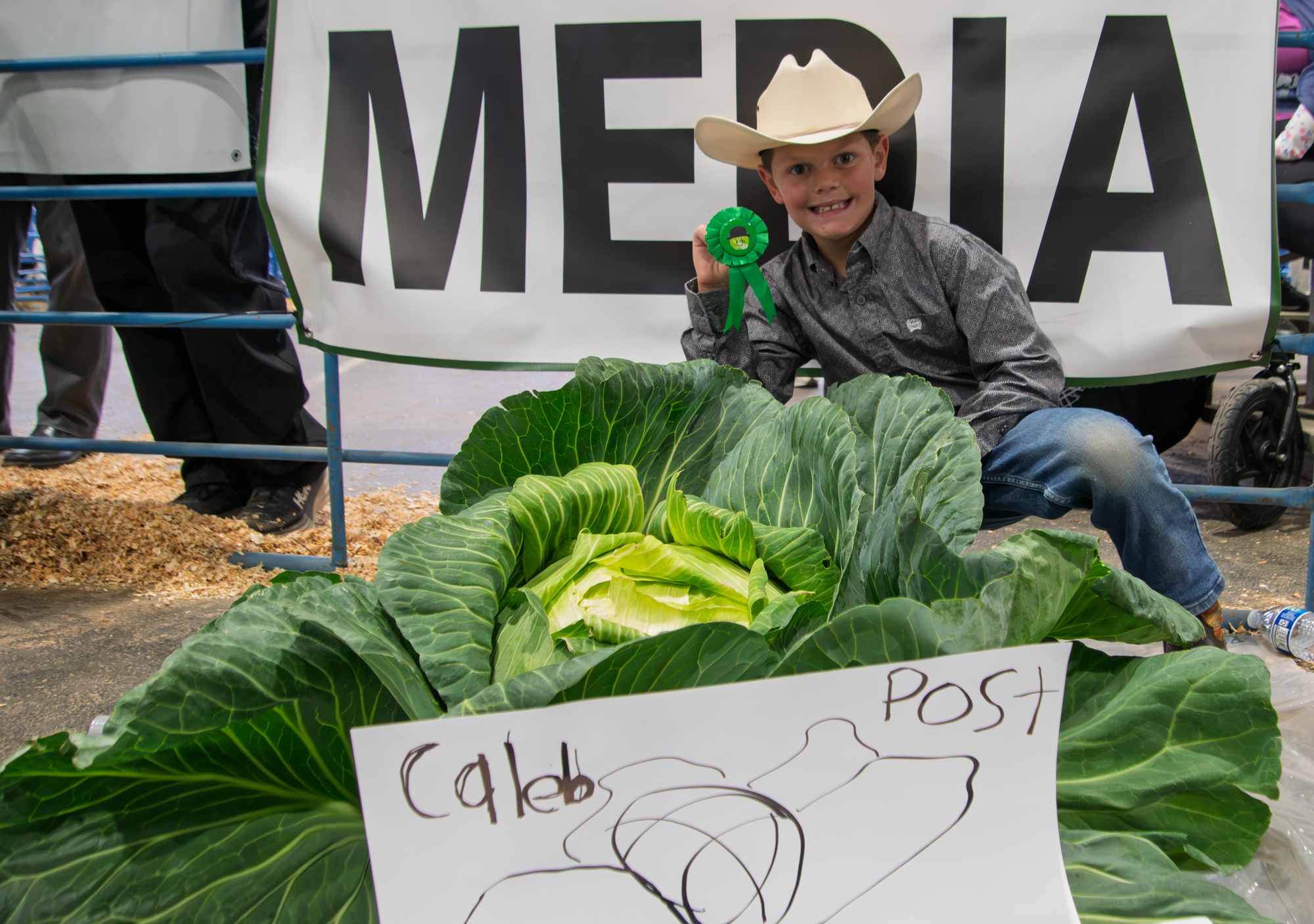 Caleb Post poses with a ribbon in front of his cabbage
