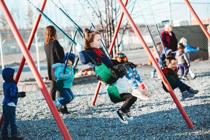 Students swing on a playground at Meadow Lakes Head Start in Wasilla, Alaska