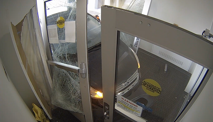 A still from a Wasilla Police Department security camera shows an individual spraying bear spray from a window after driving a vehicle into the foray of the Wasilla Police Department 