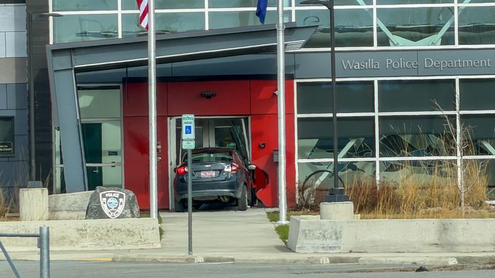 A black sedan sits in the doorway of the Wasilla Police Department headquarters