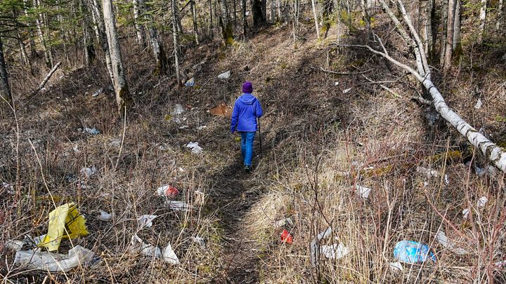 Kathi Baldwin walks on a trash-littered trail near Mat-Su College on May 11, 2026.