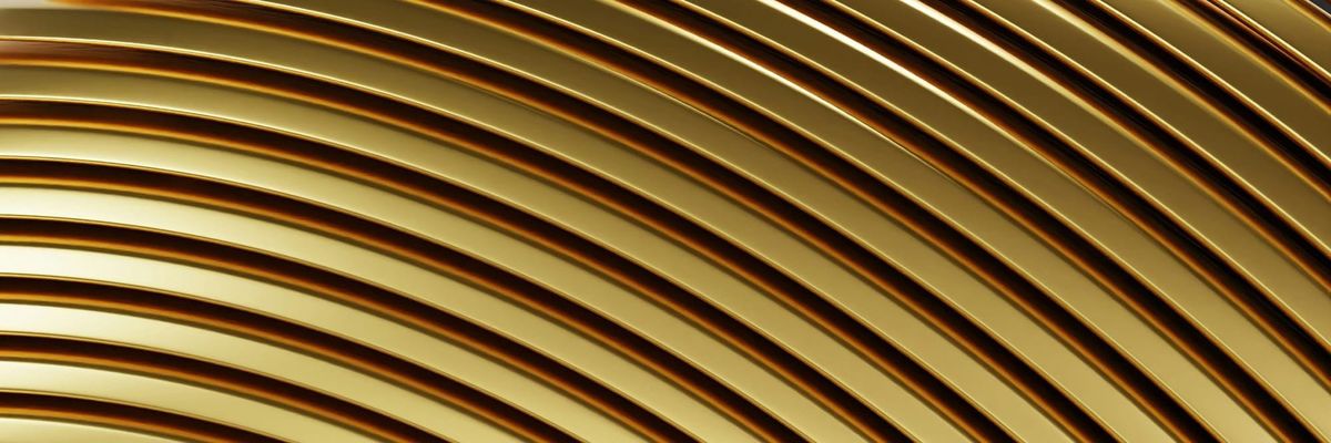 Abstract close-up of curved, polished gold bands catching the light