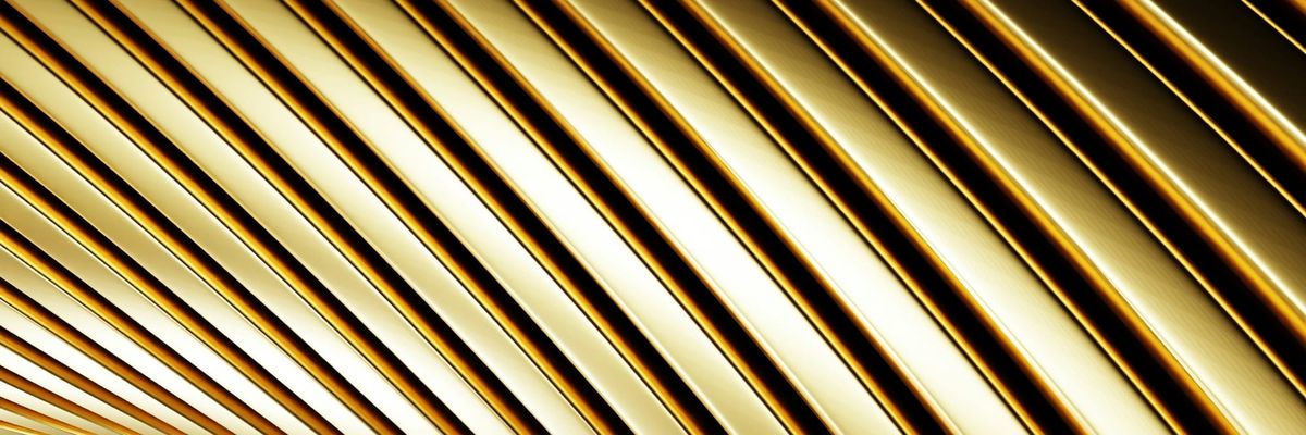Abstract close-up of curved, polished gold bands catching the light
