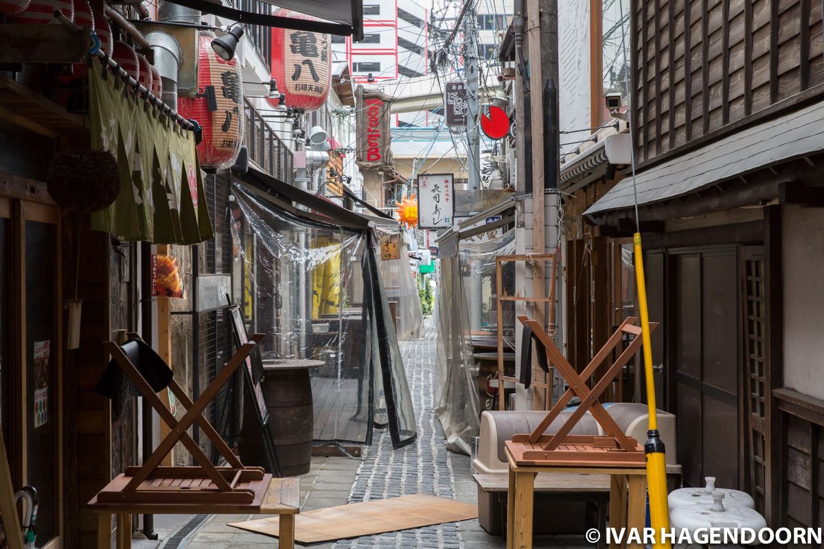 A narrow alley lined with restaurants in Osaka