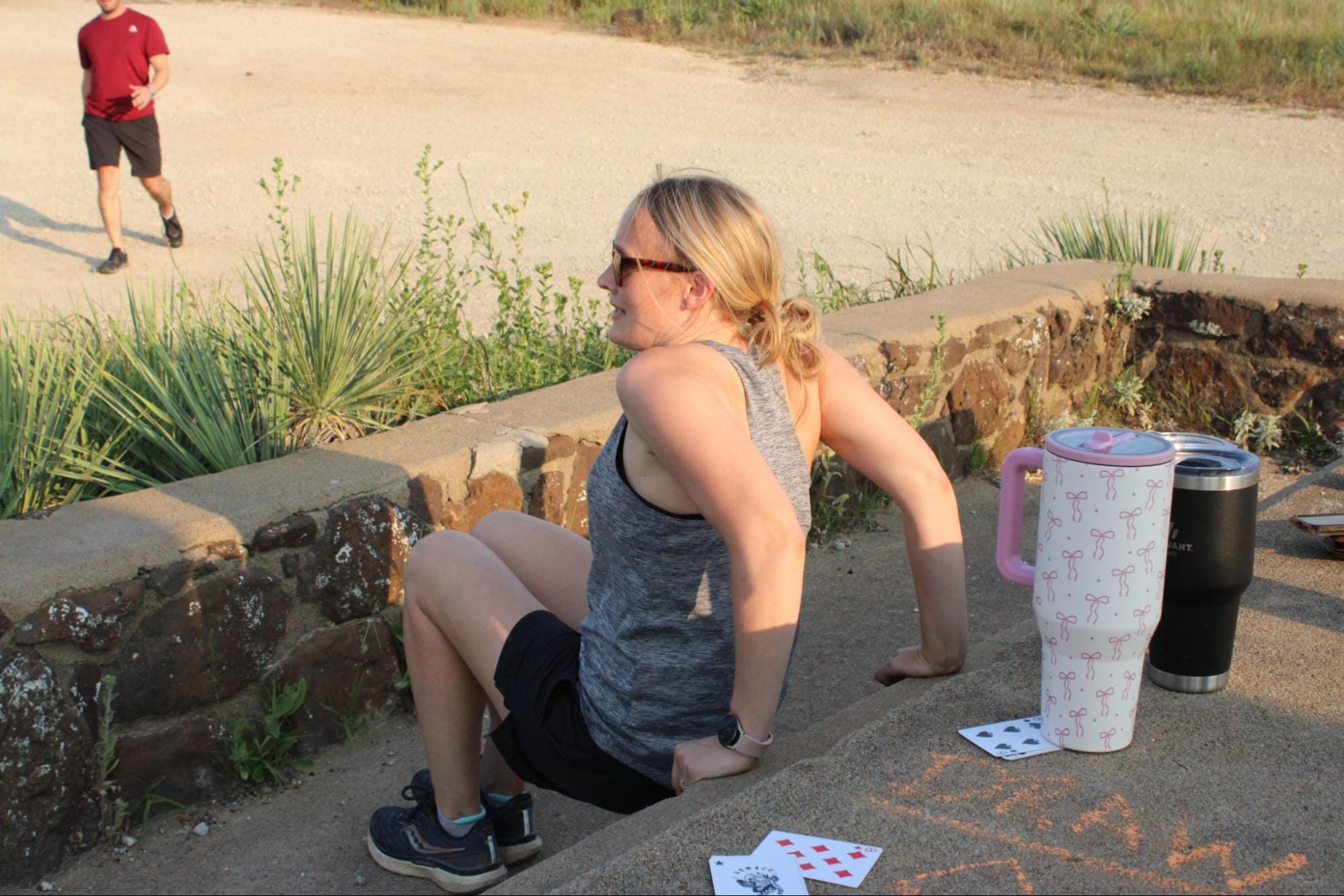Elizabeth Allison does a core workout as part of Sweaty Swedes at Coronado Heights on Aug. 3, 2026. Allison subsequently ran another lab up and down the hill as part of the workout. (Sarah Newberry/citizen journal)