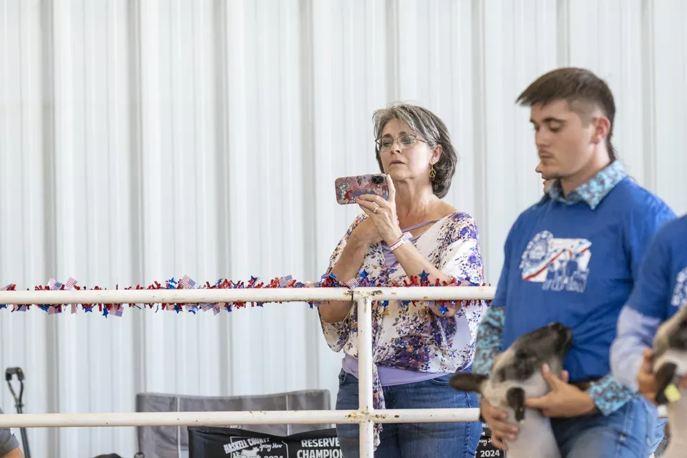 A supporter takes photos on her phone during the Senior Sheep Showmanship contest during the Kansas State Fair in Hutchinson, Kan. on Sept. 13, 2026. (Dale Grosbach for Citizen Journal)