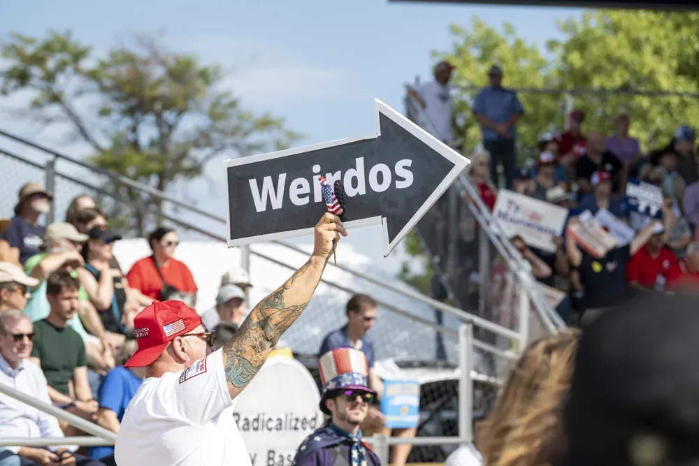A supporter of Donald Trump holds up a sign that calls Kansas gubernatorial candidates weirdos at the Kansas State Fair debate on Sept. 12, 2026. (Dale Grosbach for Citizen Journal)