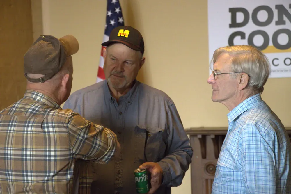 Former Sen. Jon Tester, D-Mont., center, and Don Coover, left, who is running as a Democrat in Kansas' 2nd Congressional District, speak with a potential voter during an event in Leavenworth, Kan., on Monday, Oct. 19, 2026. (Matthew Petillo/Citizen Journal)