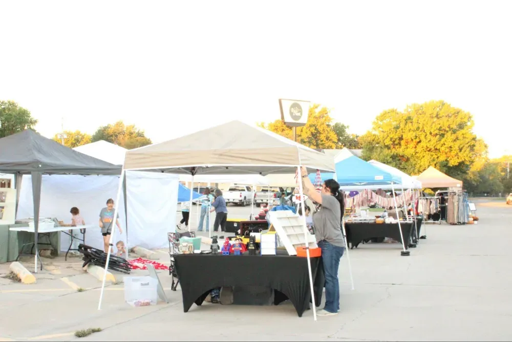 Rachael Thompson, who owns a 3D printing booth, Gothic League by Thompson, sets up early in the morning before the rush of festival-goers at the Hesston Festival in Hesston, Kan., on Saturday, Oct. 10, 2026. (Sarah Newberry/Citizen Journal)