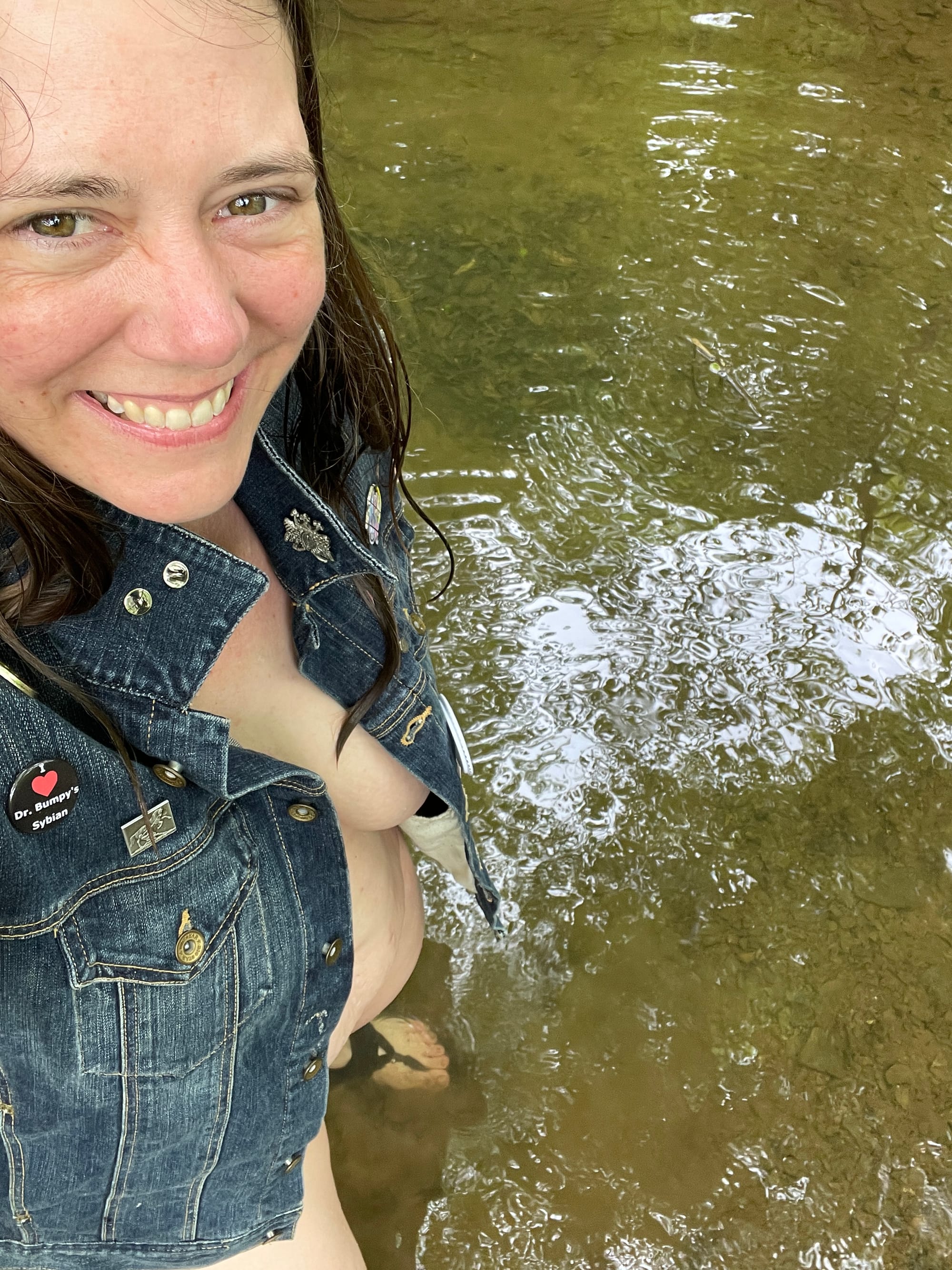 woman in a denim jacket standing in a creek