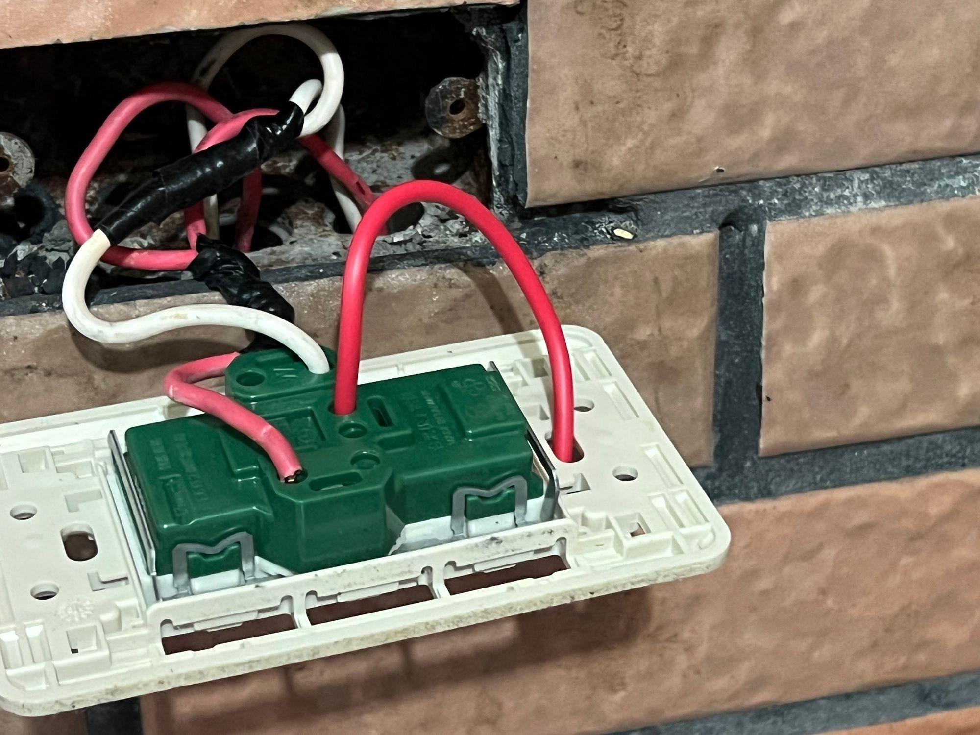 一邊插進背面的地線孔，一邊穿出螺絲孔。