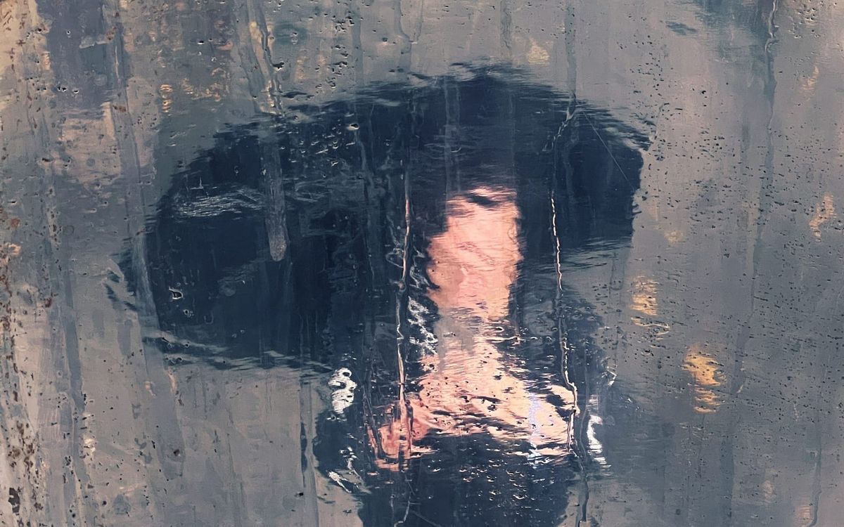 Surreal impression of a man holding a phone and an umbrella, reflected on a metallic surface dripping with rain