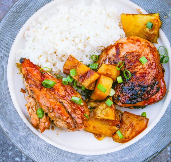 Vue de haut de morceaux de poulet huli-huli avec des morceaux d'ananas et du riz blanc.