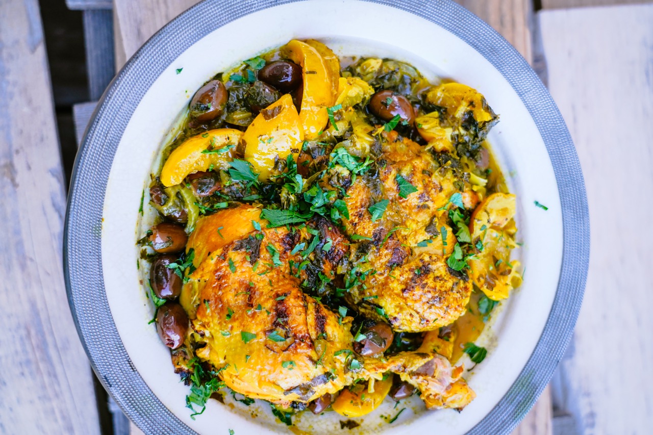 Un Tajine de poulet bien jaune avec des morceaux de citrons