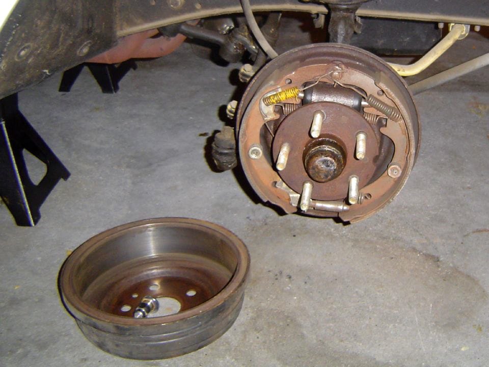 Drum brake (upper right) with the drum removed (lower left, inside facing up). https://www.flickr.com/people/ryanfrost/, CC BY 2.0, via Wikimedia Commons