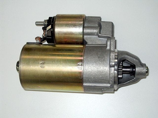 A starter motor (larger cylinder). The smaller object on top is a starter solenoid which controls power to the starter motor. Willdre 00:20, 8 February 2007 (UTC), CC BY-SA 3.0, via Wikimedia Commons