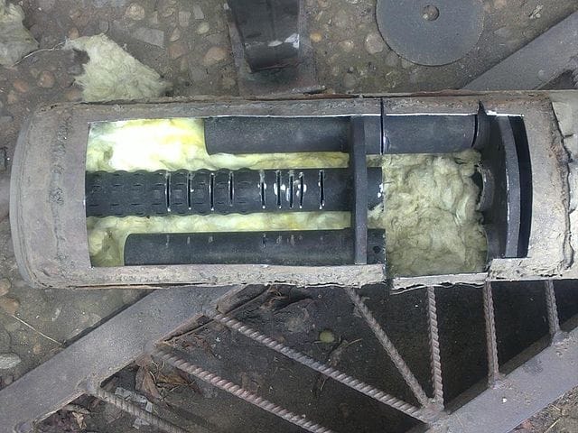 silencer cut open to show the insulation, chambers and piping inside.