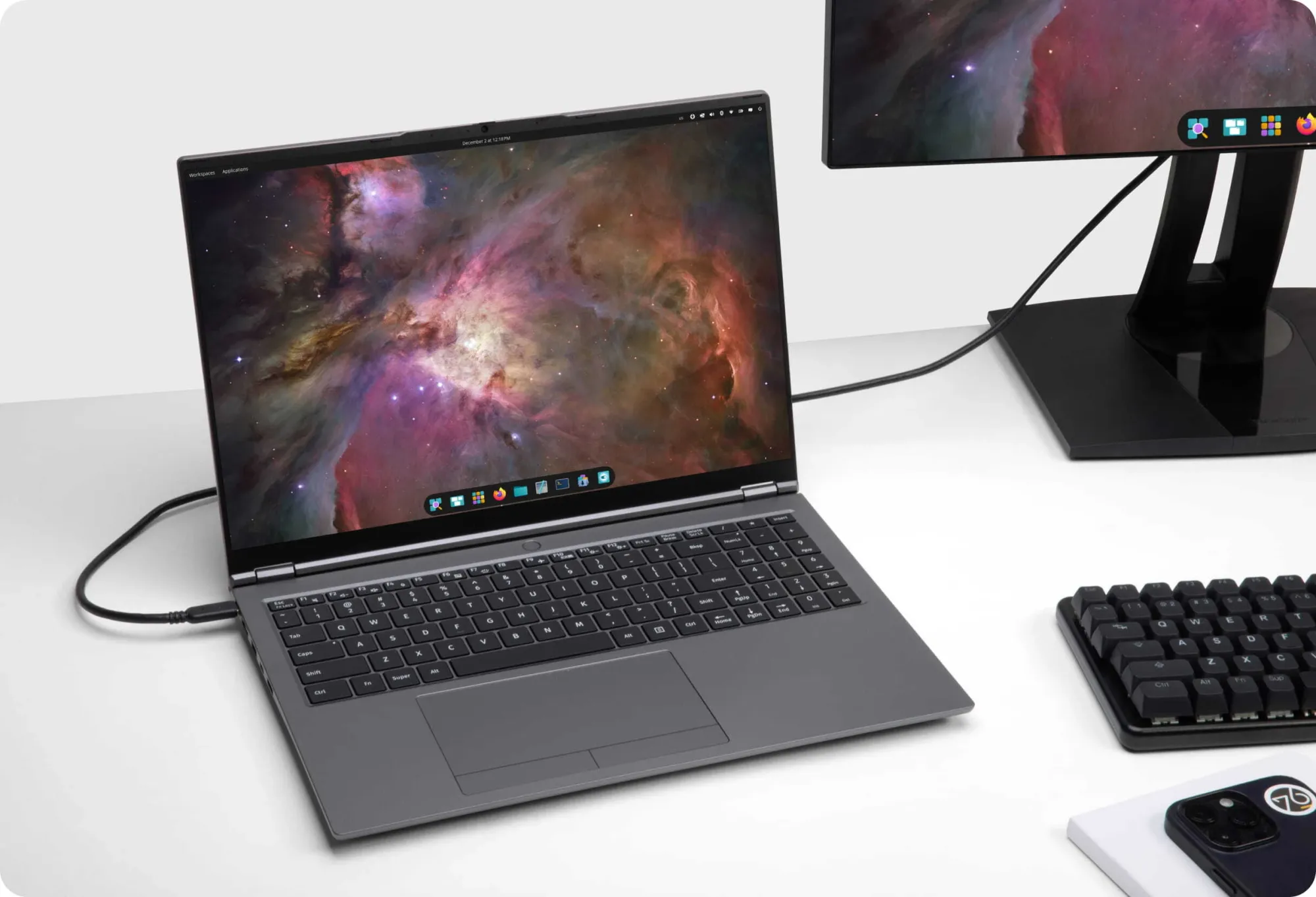 The Pangolin Pro on a desk, with the COSMIC desktop environment on the display and an attached monitor.