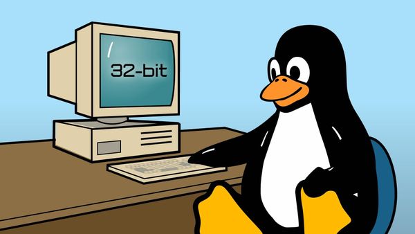 The Tux Linux mascot sitting at a desk with a vintage computer with the words "32-bit" written on the screen.