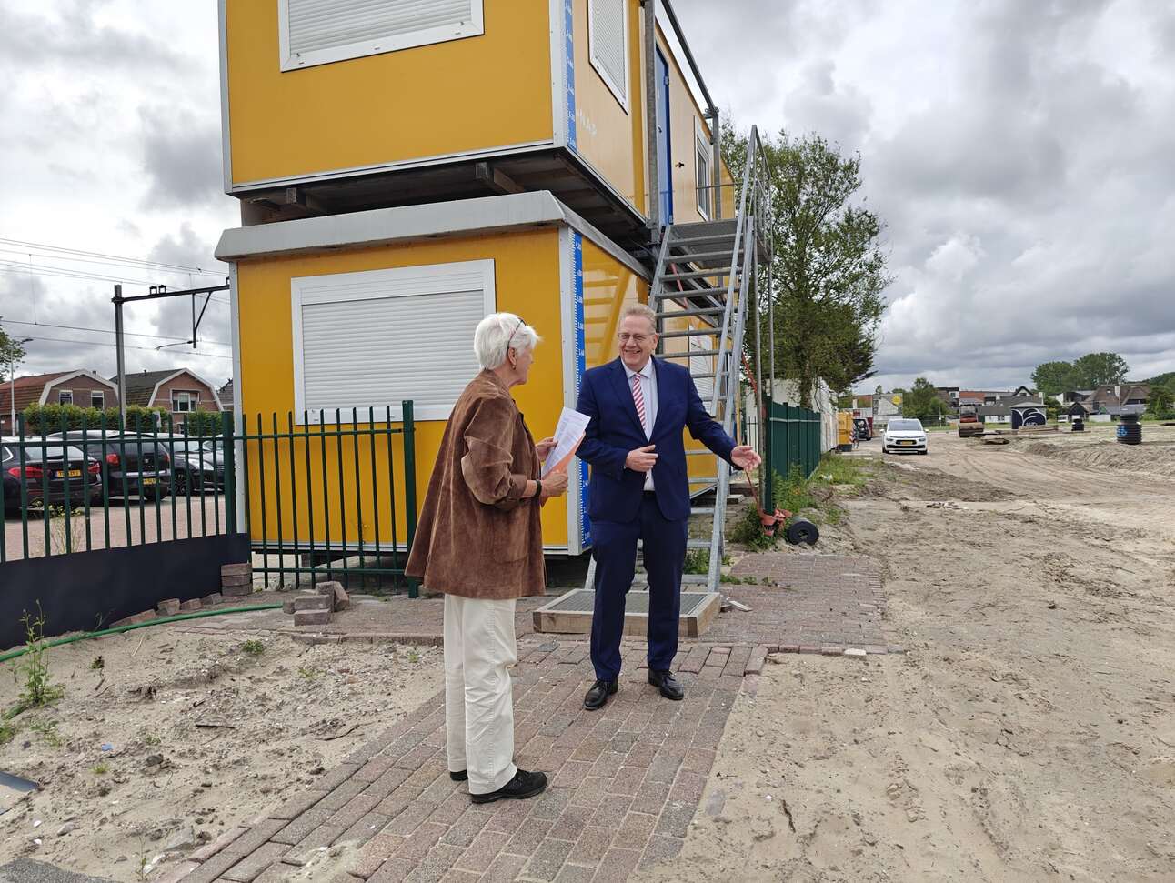 Een omwonende overhandigt wethouder Slettenhaar een petitie om aandacht te vragen voor ontstane schade aan huizen aan de Mient. Foto: Rens Blom / nieuwsuitcastricum.nl