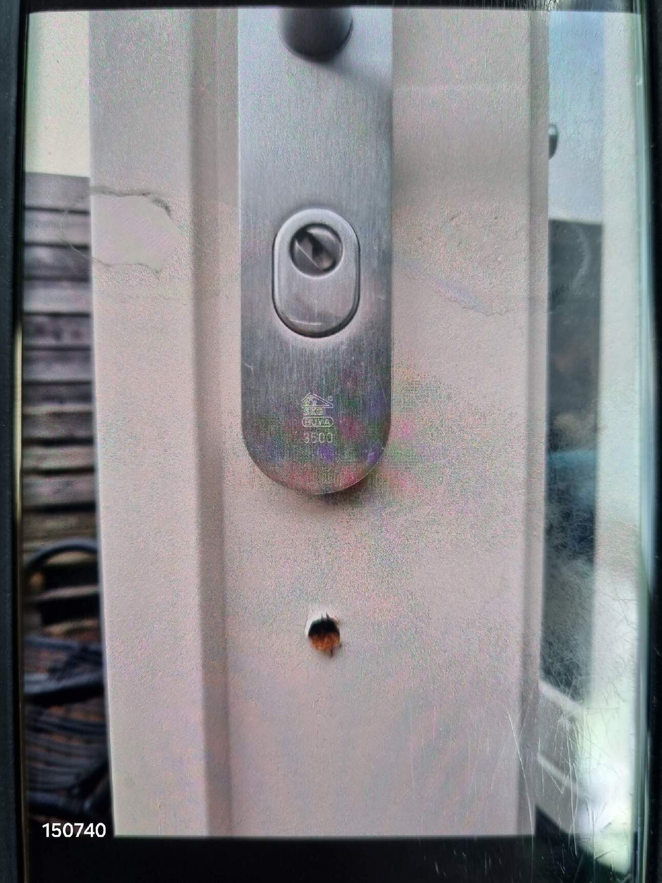 De inbreker boort een gat onder het slot van de achterdeur. Afbeelding via de politie.