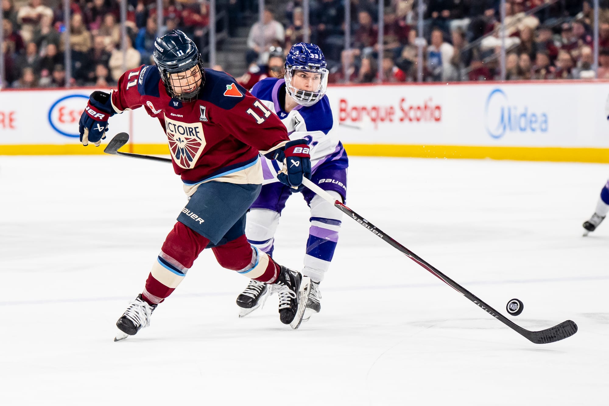 Montreal Victoire's Abby Roque (11) and Minnesota Frost's Jincy Roese (33) vie for possession of the puck during PWHL playoff hockey action. (The Canadian Press/Christopher Katsarov)