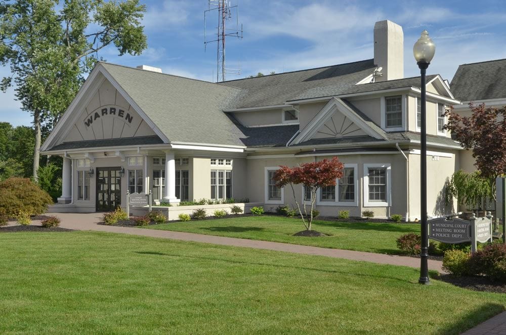 The Warren municipal building that houses the municipal court, meeting room and police department, a cream colored building with WARREN lettered on the front gable.