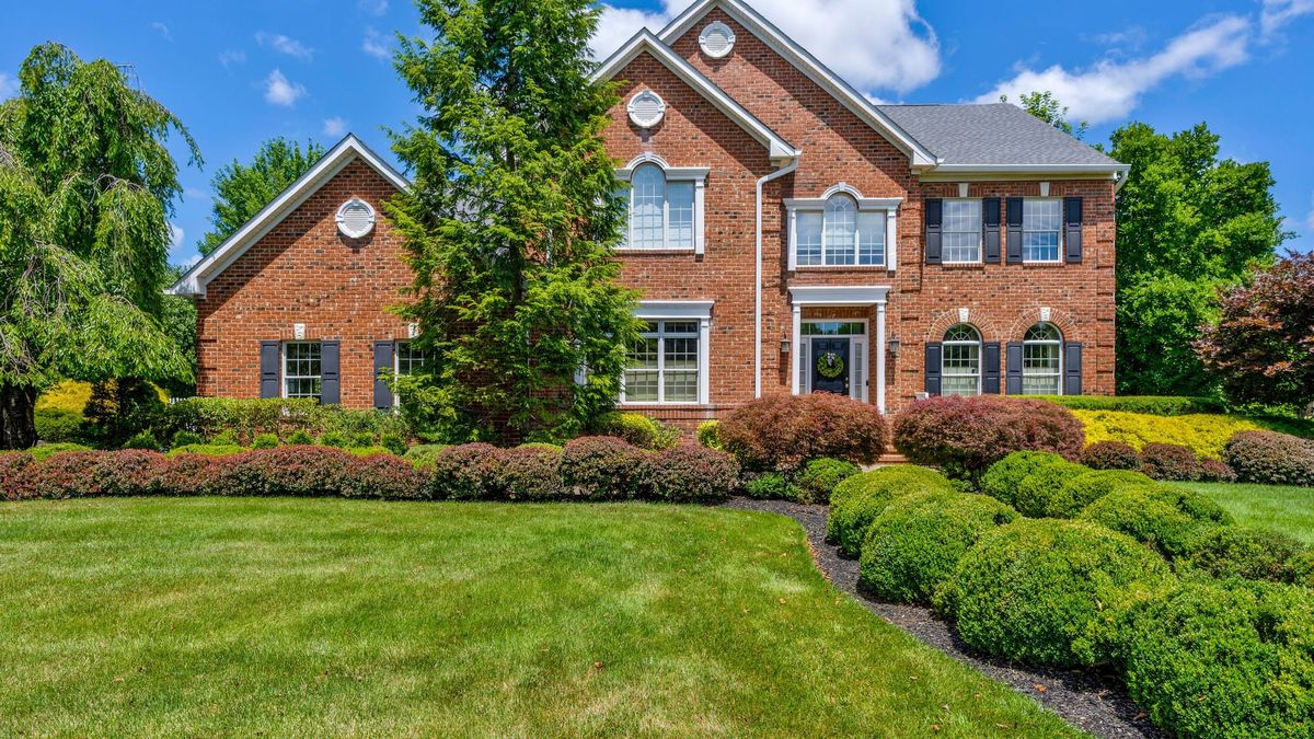 A two story brick colonial in Warren Township with black shutters, arched windows and a deep front lawn, the kind of house that now sells above the conforming loan limit.
