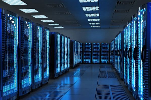 Rows of illuminated server racks lining an aisle inside a data center. Illustrative, not a Warren Township facility.